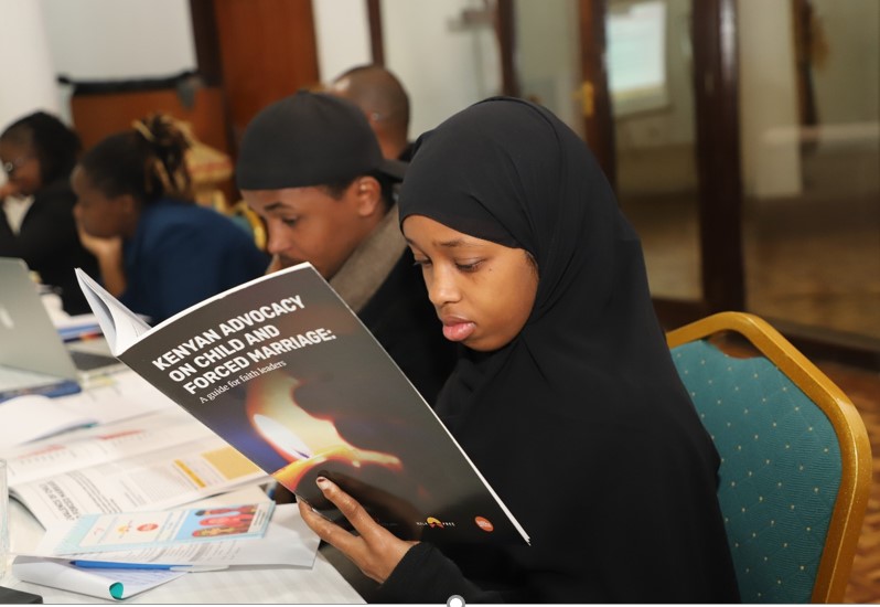 Interfaith Youth reading the advocacy guidelines for faith leaders during a training for youth advocacy of ending child and forced marriage in Kenya.